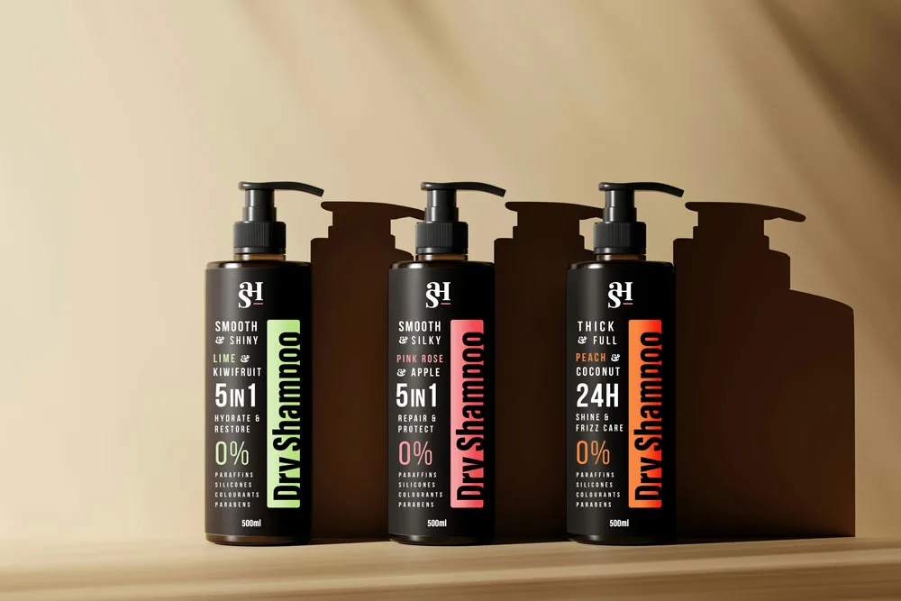 Three black shampoo bottles stand on a shelf, showcasing the typographical packaging design elements on the bottles.
