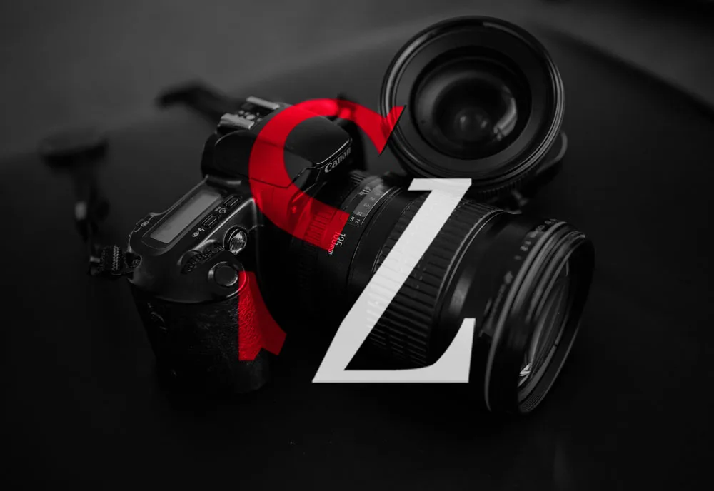 S & Z monogram logo for Shortie Zito Photography. The design features a red 'S' with its lower curve cut diagonally and a 'Z' closely positioned, with its top also cut diagonally. Positioned on a grey-scale image of a camera.