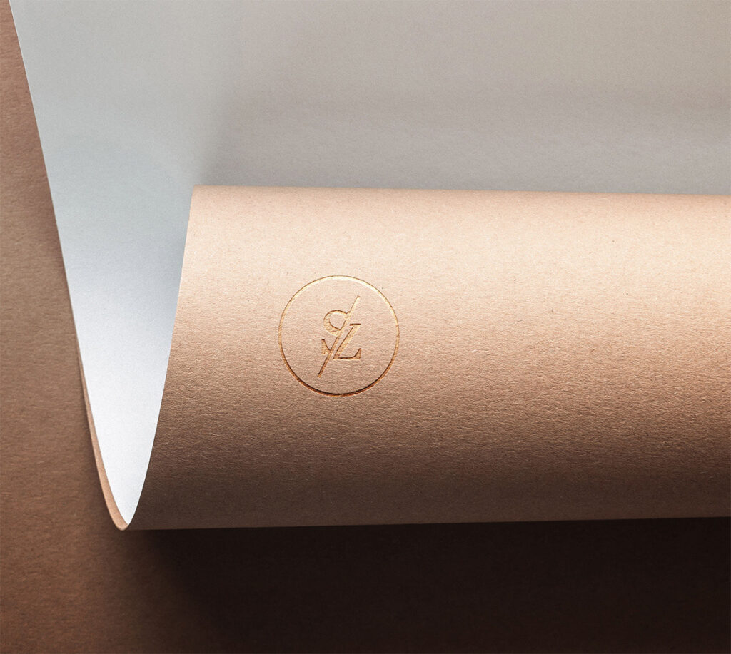 the image shows a premium paper stock slightly rolled up into it's self with the brown outerlayer showing the monogram logo for Shortie Zito Photography. the logo consists of an S & Z that have been deconstructed surrounded by a circle.